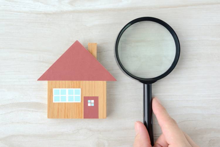 Wooden toy block house with a magnifying glass beside it